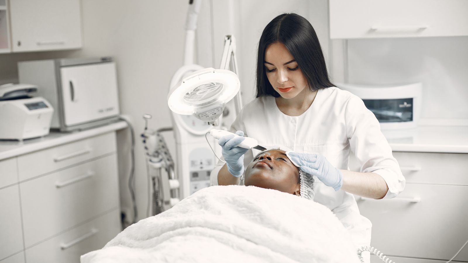 Aesthetician giving a facial treatment in a calm treatment room