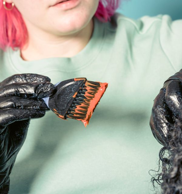 A vivid orange tone mixed and loaded on the tint brush