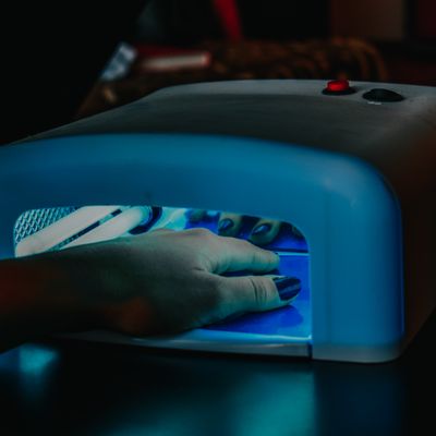 A client's hand curing gel polish at Polish, a nail salon demo