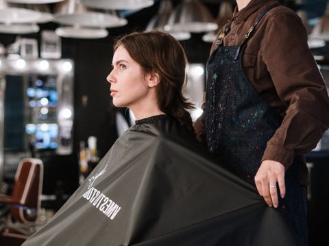 A stylist colouring a client's hair in the salon