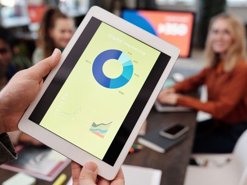 A hand holding a tablet showing the day's numbers